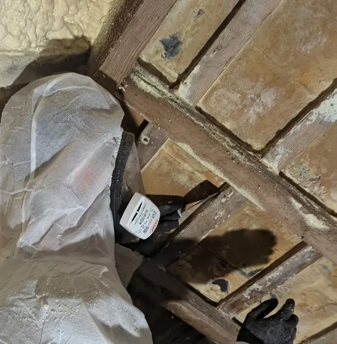 A Spray Foam Removal Specialist removing closed cell spray foam from tiles.