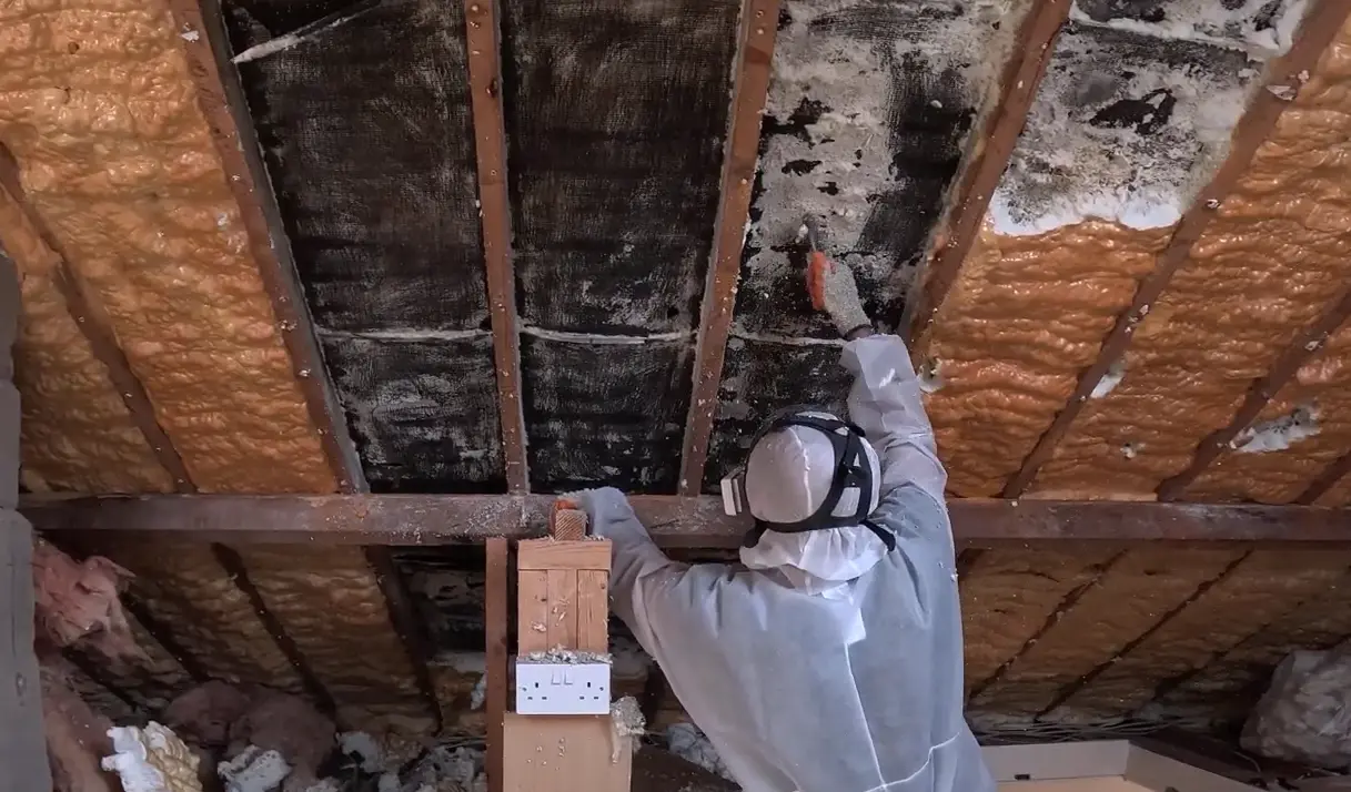 A Spray Foam Removal Specialist removing closed cell spray foam from tiles.